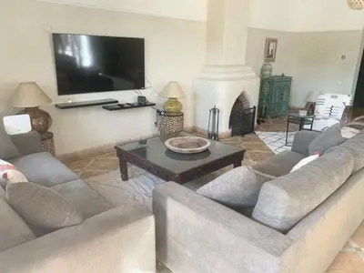 a living room with a couch and a table and a tv at Villa Mezouza in Marrakech