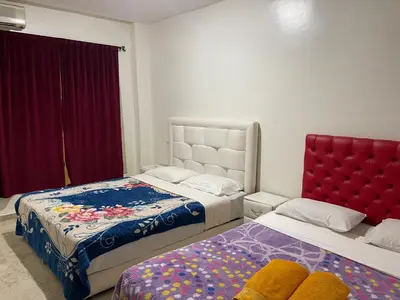 a bedroom with two beds and a red headboard at Appartement 10 1èr étage. POUR FAMILLE in Marrakech