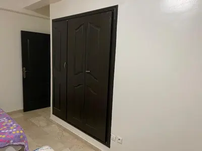 a black door on the wall of a room at Appartement 10 1èr étage. POUR FAMILLE in Marrakech