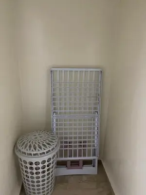 a white cage sitting next to a trash can at Appartement 10 1èr étage. POUR FAMILLE in Marrakech