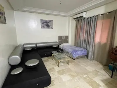 a living room with a couch and a bed at Appartement 10 1èr étage. POUR FAMILLE in Marrakech
