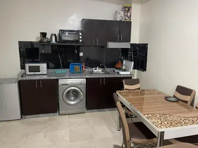 a kitchen with a washing machine and a table with chairs at Appartement 11 2èm étage. (POUR FAMILLE) in Marrakech
