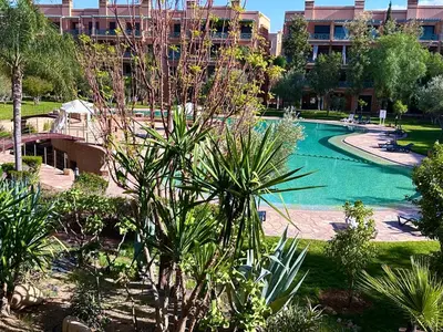 a swimming pool in front of a building at Chic Moroccan Vibes & Pool View - 2BR in Marrakech