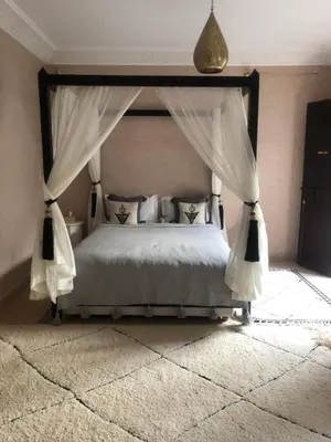 a bedroom with a bed with a canopy at Riad Jolie in Marrakech
