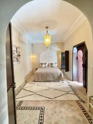 a bedroom with a bed and a chandelier at Riad Jolie in Marrakech
