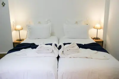 two beds with white sheets and towels on them at DAR NOUONSA in Marrakech