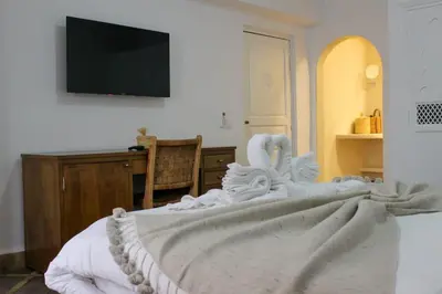 a bedroom with a bed with a tv on the wall at DAR NOUONSA in Marrakech