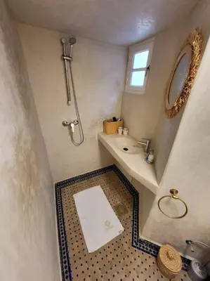 a bathroom with a shower and a sink and a mirror at DAR NOUONSA in Marrakech