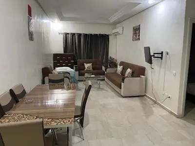 a living room with a couch and a table at Appartement 13 2em étage POUR FAMILLE in Marrakech
