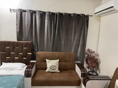 a bedroom with a bed and a chair and a window at Appartement 13 2em étage POUR FAMILLE in Marrakech