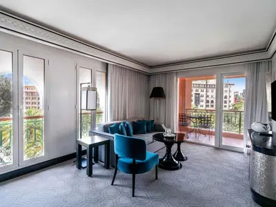 a living room with a couch and a table and windows at Sofitel Marrakech Palais Impérial & Spa in Marrakech