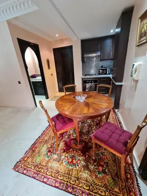 a kitchen with a wooden table and chairs on a rug at Luxury apartment 2 in the heart of Gueliz, Wifi, Pool in Marrakech