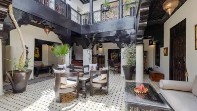 a room with chairs and tables in a building at Dar Najat in Marrakech