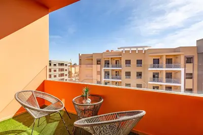 a balcony with chairs and a plant on a building at favorite in the city center - 100% Equipped in Marrakech