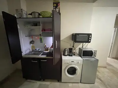 a small kitchen with a washing machine and a microwave at Appartement 16 2èm étage ( POUR FAMILLE ) in Marrakech