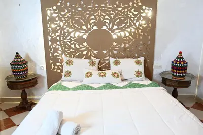 a bedroom with a white bed with two night stands at Riad sarsar airport in Marrakech
