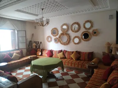 a living room with couches and mirrors on the wall at Riad sarsar airport in Marrakech