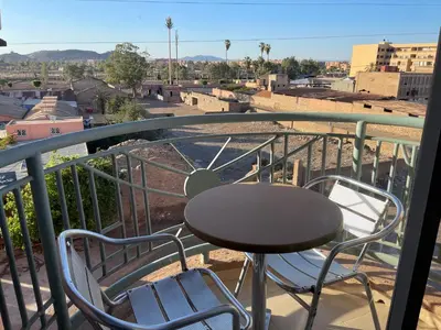 a table and two chairs on a balcony at Appartement 18 3èm étage avec balcon ( POUR FAMILLE ) in Marrakech