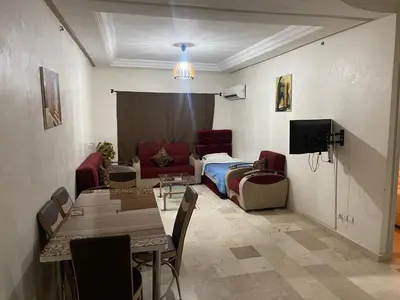 a living room with a couch and a table at Appartement 19 3èm étage ( POUR FAMILLE ) in Marrakech
