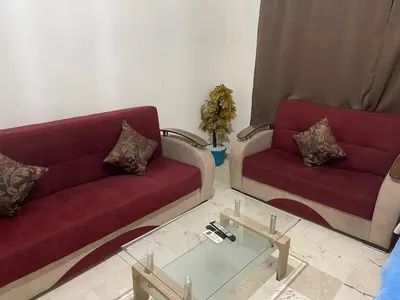 a living room with two red couches and a glass table at Appartement 19 3èm étage ( POUR FAMILLE ) in Marrakech
