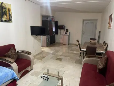 a living room with two couches and a dining room at Appartement 19 3èm étage ( POUR FAMILLE ) in Marrakech