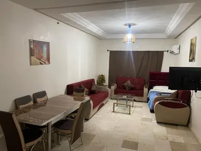 a living room with a table and a couch at Appartement 19 3èm étage ( POUR FAMILLE ) in Marrakech