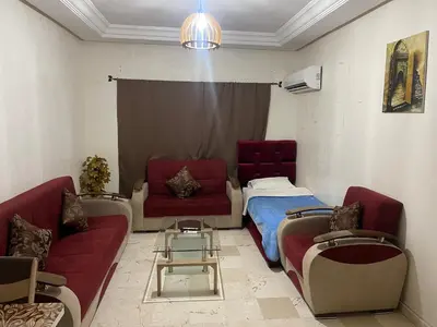 a living room with a couch and a bed at Appartement 19 3èm étage ( POUR FAMILLE ) in Marrakech