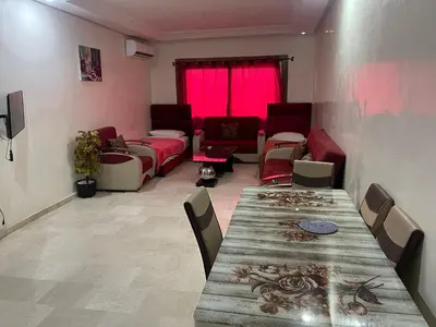 a living room with a long table and a couch at Appartement 20 3èm étage avec balcon ( POUR FAMILLE ) in Marrakech