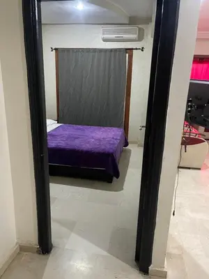 a bedroom with a purple bed and a mirror at Appartement 20 3èm étage avec balcon ( POUR FAMILLE ) in Marrakech