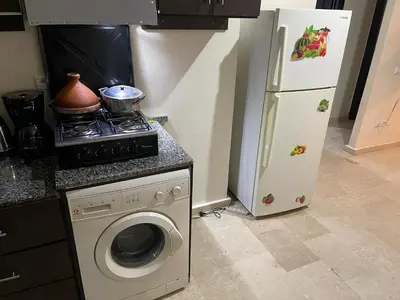 a kitchen with a stove and a refrigerator at Appartement 22 au 3ème étage ( POUR FAMILLE ) in Marrakech