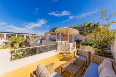 a patio with furniture and an umbrella on a balcony at Riad XO in Marrakech