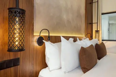 a bedroom with a bed with white pillows at Le Meridien N'fis in Marrakech