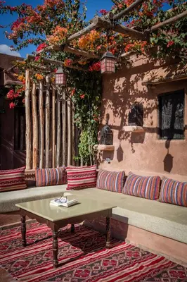 a patio with a bench and a table and flowers at Jnane Leila in Marrakech