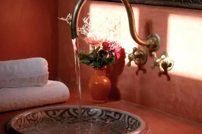 a bathroom sink with a vase with flowers in it at Jnane Leila in Marrakech