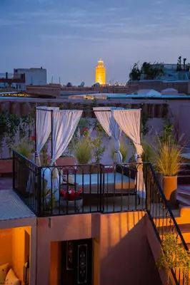 a balcony with umbrellas on top of a building at Riad Ta'achchaqa in Marrakech