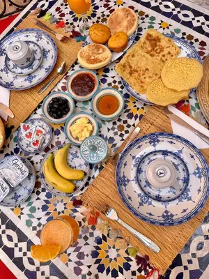 a table with blue and white plates of breakfast food at Riad Shaden in Marrakech