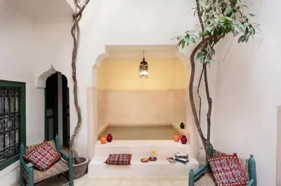a living room with two chairs and two trees at Dar Touyir in Marrakech