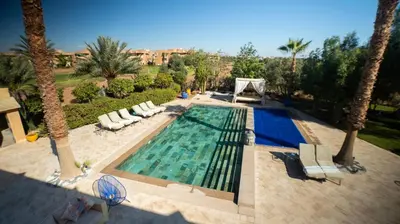an overhead view of a swimming pool with palm trees at Villa de rêve à Marrakech in Marrakech