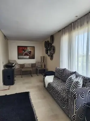 a living room with a couch and a tv at Villa de rêve à Marrakech in Marrakech
