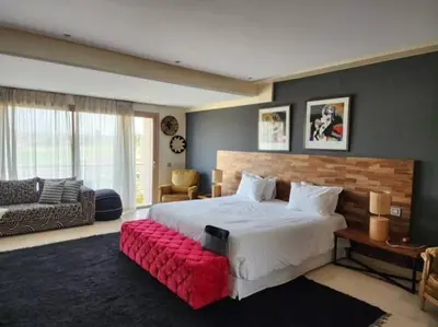 a bedroom with a large bed with a red bench at Villa de rêve à Marrakech in Marrakech