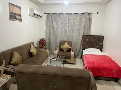 a living room with a couch and a bed at Appartement 23 4èm étage avec balcon ( POUR FAMILLE ) in Marrakech