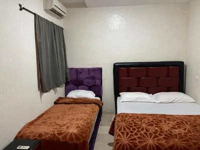a small room with two beds and a window at Appartement 23 4èm étage avec balcon ( POUR FAMILLE ) in Marrakech