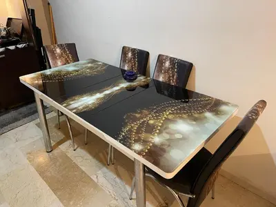 a dining table with four chairs and a glass table with a table at Appartement 23 4èm étage avec balcon ( POUR FAMILLE ) in Marrakech