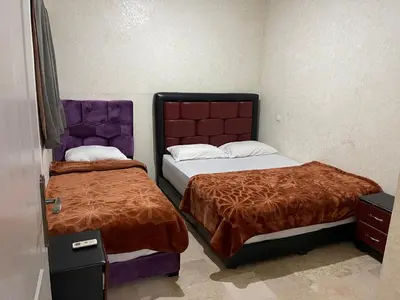 two beds in a small room with two bedsskirts at Appartement 23 4èm étage avec balcon ( POUR FAMILLE ) in Marrakech