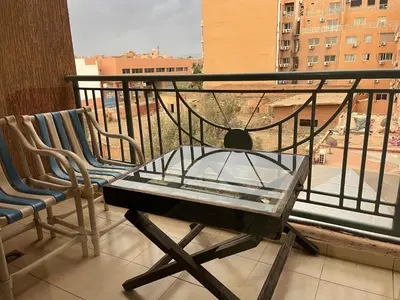 a balcony with a glass table and two chairs at Appartement 23 4èm étage avec balcon ( POUR FAMILLE ) in Marrakech