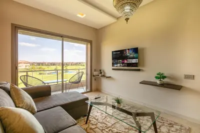 a living room with a couch and a large window at Perle Rare a Prestigia - Vue Sur Golf in Marrakech