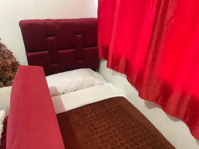 a bed in a room with a red curtain at Appartement 24 4èm étage avec balcon ( POUR FAMILLE ) in Marrakech