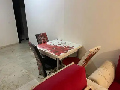 a living room with a table and a couch at Appartement 24 4èm étage avec balcon ( POUR FAMILLE ) in Marrakech