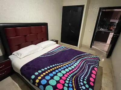 a bedroom with a large bed with a colorful blanket at Appartement 24 4èm étage avec balcon ( POUR FAMILLE ) in Marrakech