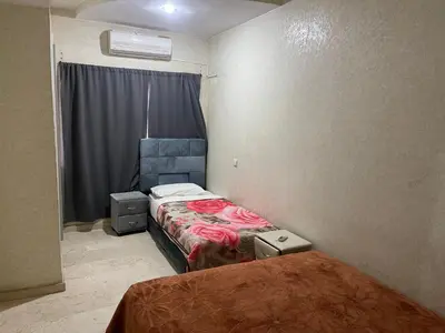 a small room with two beds and a window at Appartement 25 4èm étage ( POUR FAMILLE ) in Marrakech